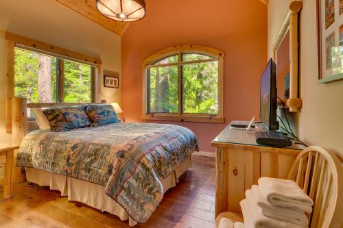 a bedroom with a bed and a desk and windows at Tippy Canoe by Tahoe Getaways - 4BR West Shore w Private Hot Tub,, Sauna, EV & Walking Distance to Trailhead in Tahoma
