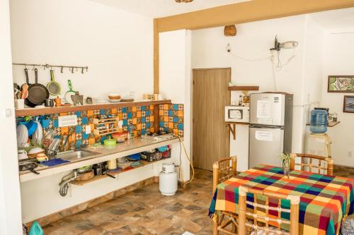 a kitchen with a table and a sink and a refrigerator at Casa Mazunte Tierra Viva in Mazunte