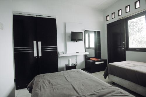 sypialnia z łóżkiem i dużą czarną szafą w obiekcie Wis-Inn Wisma Industri w mieście Tagalbato