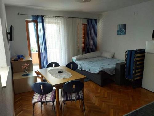 um quarto com uma mesa e uma cama e cadeiras em Apartments by the sea Pirovac, Sibenik - 21874 em Pirovac