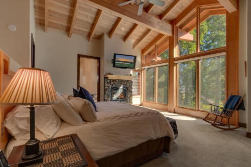 a bedroom with a large bed in a room with windows at Gray Bear Lake View Estate - Stunning Cabin w 4 Master Suites, Private Hot Tub! in Carnelian Bay