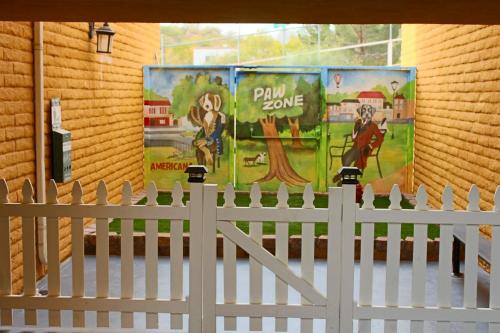 a white fence in front of a building with posters at Hotel Americana in Nogales