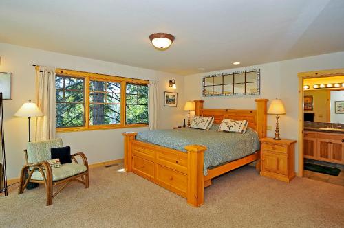 una camera da letto con un letto e una sedia di Sierra Crest at Palisades Tahoe - Secluded Luxury 5BR 5 BA w Wood Fireplace a Olympic Valley