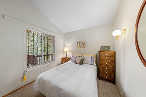 a white bedroom with a bed and a window at Starry Skies on the West Shore, Private Beach, Fireplace, Pet Friendly, Close to Ski Resorts in Tahoe City