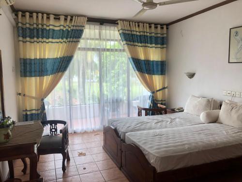 1 dormitorio con cama y ventana grande en Hotel Lagoon Paradise, en Negombo