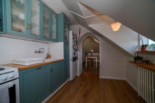 una cocina con armarios azules y una escalera en Cozy apartment in the heart of Reykjavík! en Reikiavik