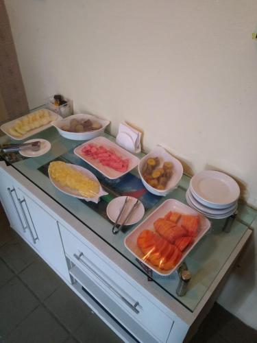 a counter top with many different dishes of food at POUSADA CÉU AZUL in Porto De Galinhas