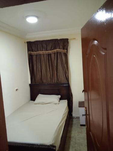 - une petite chambre avec un lit et une fenêtre dans l'établissement HeliopolisStar, au Caire