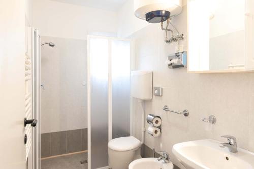 ein weißes Bad mit einem WC und einem Waschbecken in der Unterkunft Relax in the terrace of our flat - Beahost in Lignano Sabbiadoro