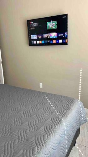 a bedroom with a bed and a tv on the wall at Paradise Oasis! Waterfall pool & spa in Lake Havasu City