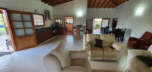 sala de estar con 2 sofás y cocina en Villa Emita - MESA DE LOS SANTOS, en Los Santos