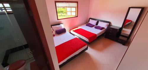 2 camas en una habitación pequeña con espejo en Villa Emita - MESA DE LOS SANTOS en Los Santos