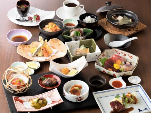 a table with plates of food and bowls of food at Hotel Morinokaze Oshuku in Shizukuishi