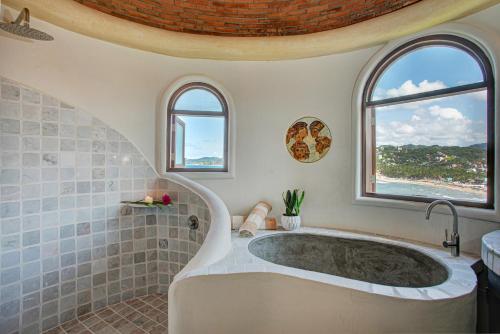 - Baño con bañera y 2 ventanas en Romantic Luxury Villa, en Sayulita
