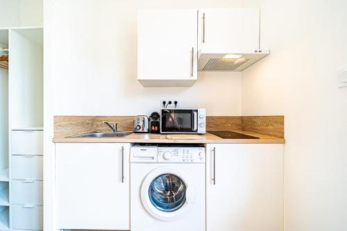 une cuisine avec un lave-linge et un micro-ondes dans l'établissement Le Debourg - Studio tout proche métro B, à Lyon