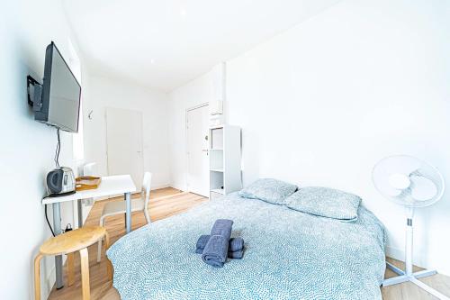 une chambre avec un lit, un bureau et une télévision dans l'établissement Le Debourg - Studio tout proche métro B, à Lyon
