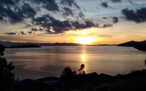 a sunset over a large body of water at Quilla Wasi - ISLA DEL SOL in Comunidad Yumani