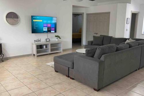 a living room with a couch and a flat screen tv at Spacious Getaway! Pool, Spa, Sleeps 9 in Lake Havasu City