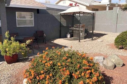 a backyard with a grill and some orange flowers at Spacious Getaway! Pool, Spa, Sleeps 9 in Lake Havasu City