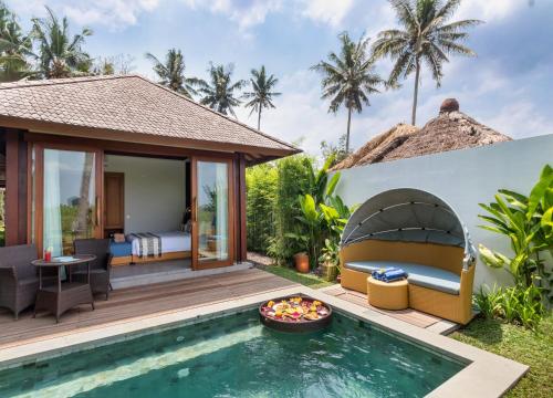 a villa with a pool and a bedroom at Suga Estate - Rice Field View Villas in Ubud