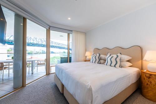 a bedroom with a large bed and a view of a bridge at Story Bridge view apartment with parking and pool in Brisbane