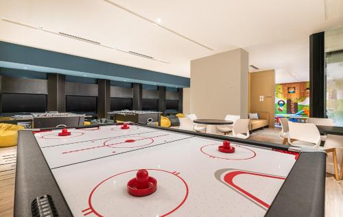 a large ping pong table in a room with chairs at Seda Manila Bay in Manila