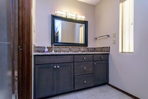 a bathroom with a black vanity and a mirror at Bright & spacious home with pool in Albuquerque