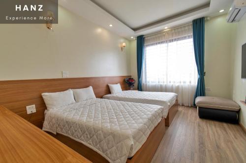 Cette chambre comprend 2 lits et une fenêtre. dans l'établissement HANZ Noi Bai Airport Hotel, à Hanoï
