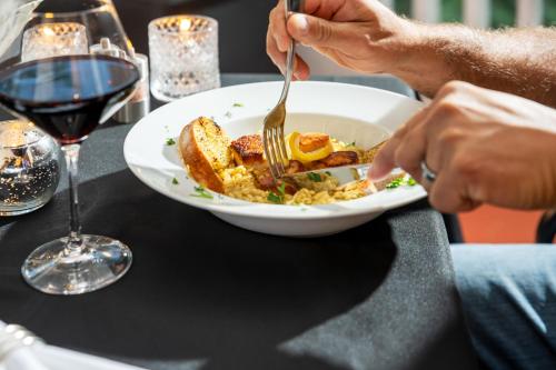 a person eating a plate of food with a fork at Sheridan House Inn- Adult Only Accommodation in Williams