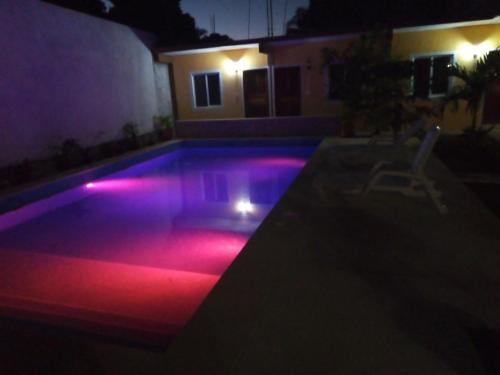 a pool with red lights in a backyard at night at Casa Terracota in Bacalar
