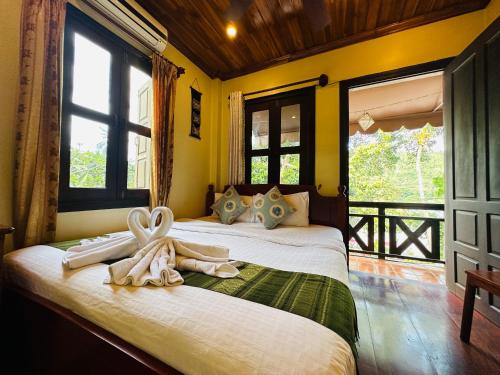 a bedroom with a bed with towels on it at Anisa Mekong Riverside Villa in Luang Prabang