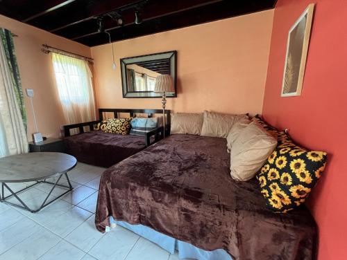 STUNNING 2 Bedroom House at Point Village Negril في نيغريل: غرفة نوم بسرير وطاولة في غرفة
