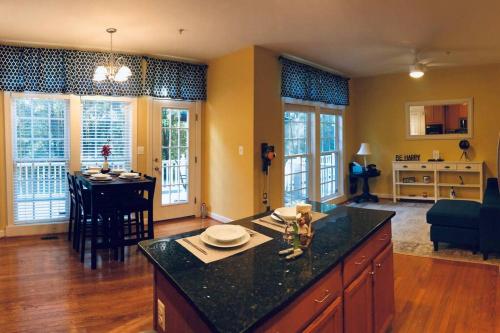 a kitchen and living room with a island and a table at Luxe and Modern 2 LVL Townhouse in Prime Location! in Gaithersburg