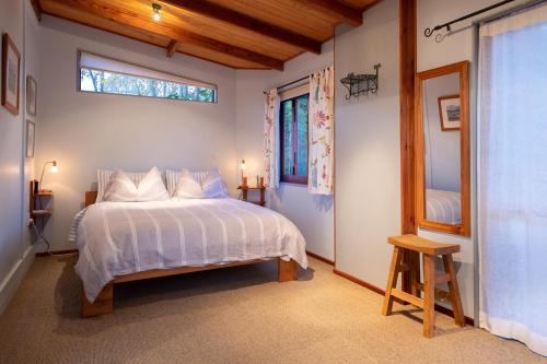 Tasman的住宿－Tasman Village Cottage，卧室配有白色的床和窗户。