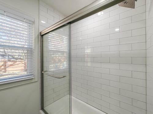a shower with a glass door in a bathroom at 4 Bedroom Plaza Charmer Pet Friendly in Kansas City