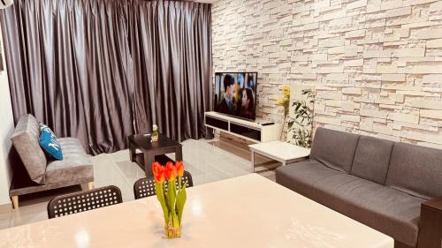 a living room with a table and a tv at D'Putra Suites 2BR Kulai by Luxecocoo CK in Kampong Saleng