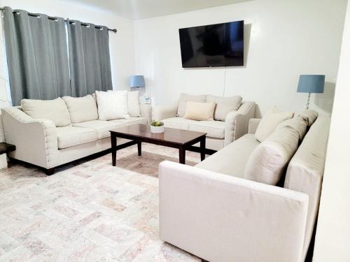 uma sala de estar com sofás brancos e uma mesa de centro em Tu Casa de Familia em Tijuana