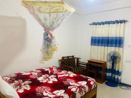 a bedroom with a bed with a red comforter at Lavendra Guset House in Adams Peak