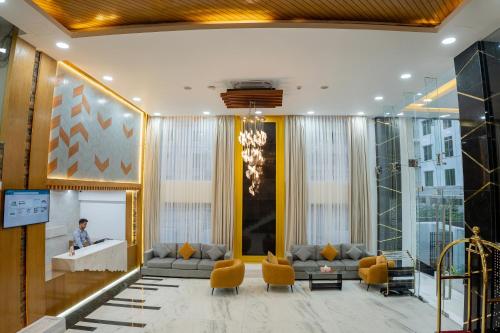 a lobby of a hotel with a couch and chairs at HOTEL STUDiO23 in Dhaka