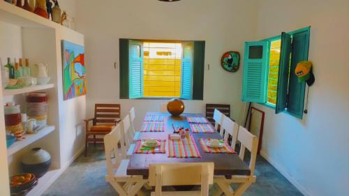 uma sala de jantar com mesa, cadeiras e janelas em Privê Sol e Mar em Cabo de Santo Agostinho