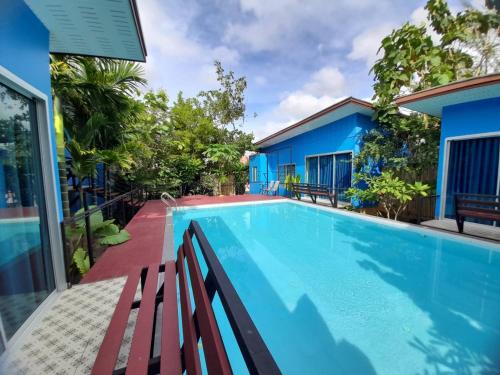 a swimming pool in front of a house at RadHut in Chalong