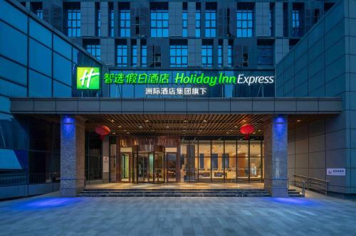 Holiday Inn Express Huangshi Cihu Lake, an IHG Hotel في Huangshi: مبنى عليه لافته مكتوب عليها horenstein express