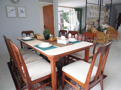 - une table à manger avec des chaises, une table, une table et des chaises dans l'établissement Rumah Ijau - Halal Homestay, à Padangluar