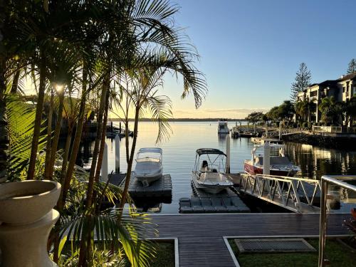 a couple of boats docked at a dock on the water at Waterfront Oasis in Runaway Bay - CoastHM in Gold Coast