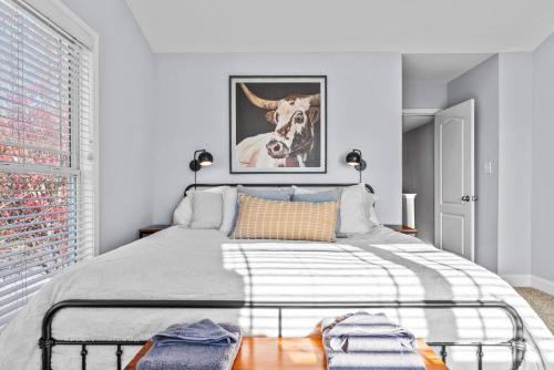 um quarto com uma cama com uma fotografia de uma vaca em Whitehall Dawg Den - Right by North Oconee River! em Athens