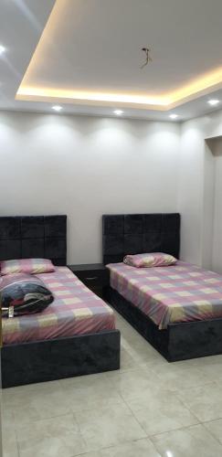 2 Betten nebeneinander in einem Zimmer in der Unterkunft شقه مفروشه علي جسر السويس جنب اسماك دولفن in Kairo