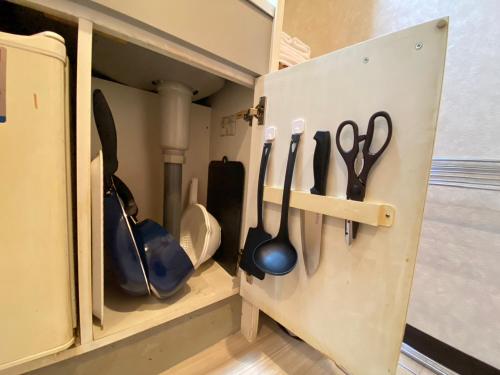 un mobiletto con dentro degli utensili di マルチステイ大阪京橋 ad Osaka