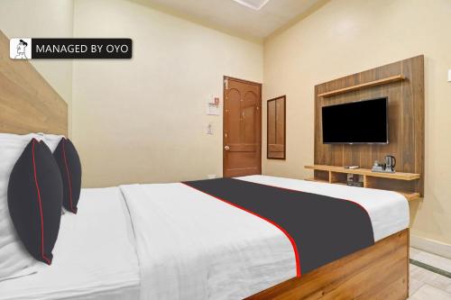 a bedroom with a large bed and a tv at Super Collection O Townvilla Guest House near Begumpet Metro Station in Hyderabad