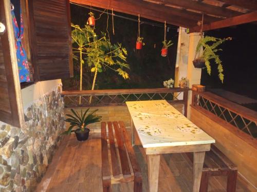 a wooden table and chairs in a room with potted plants at Chalé Ebenézer in Eldorado