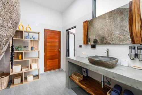uma casa de banho com um lavatório e uma porta de madeira em Nelumbo Villa - Lamai Seaview - 4 bedroom em Nathon Bay